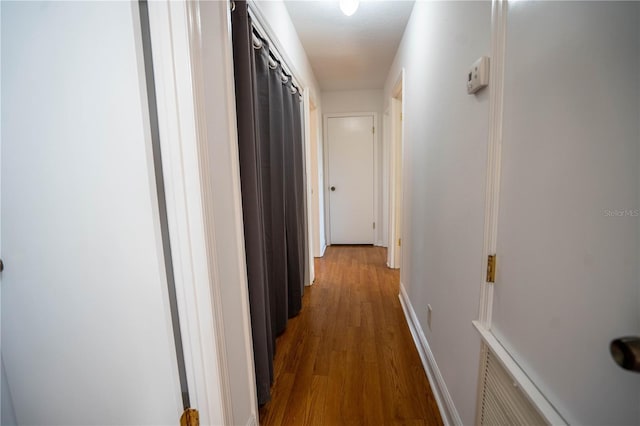 corridor with hardwood / wood-style flooring