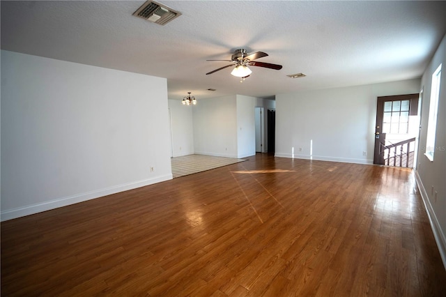 unfurnished room with a textured ceiling, dark hardwood / wood-style floors, and ceiling fan with notable chandelier