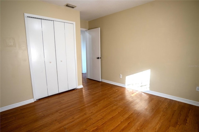 unfurnished bedroom featuring hardwood / wood-style flooring and a closet