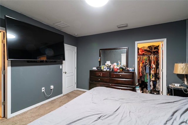 carpeted bedroom featuring a walk in closet and a closet