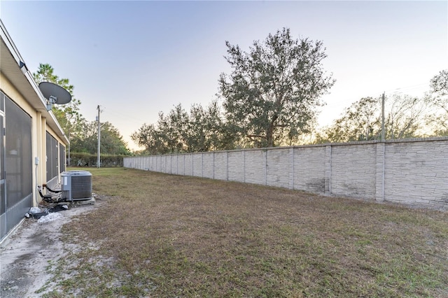 yard at dusk with central AC unit