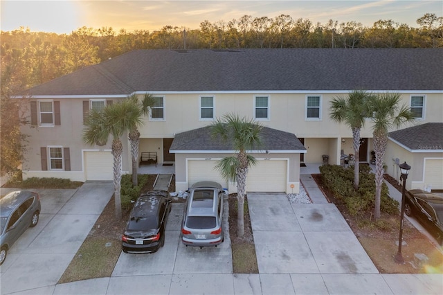 12827 Buffalo Run Dr, Gibsonton, FL 33534 - view of front facade featuring stucco siding, a garage, driveway, and a shingled roof