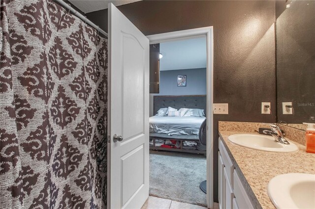 12827 Buffalo Run Dr, Gibsonton, FL 33534 - ensuite bathroom featuring double vanity, a shower with curtain, and tile patterned flooring