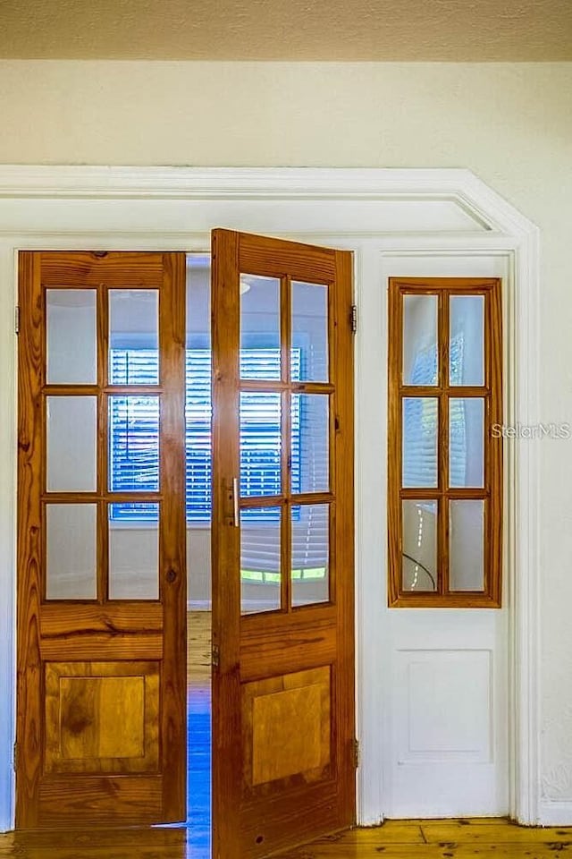 entryway featuring plenty of natural light, wood-type flooring, and french doors