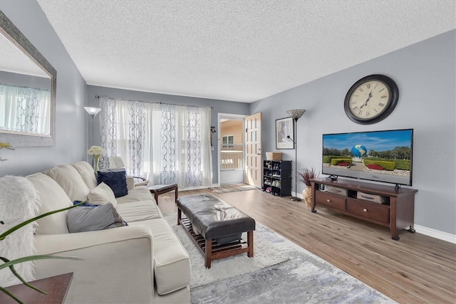 living room with a textured ceiling, hardwood / wood-style flooring, and a wealth of natural light