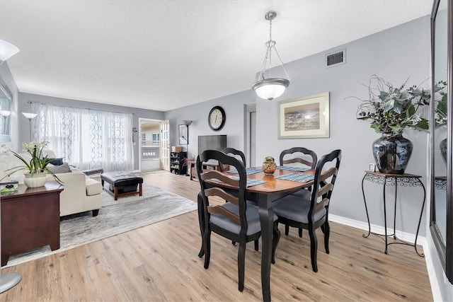 dining space with light hardwood / wood-style flooring