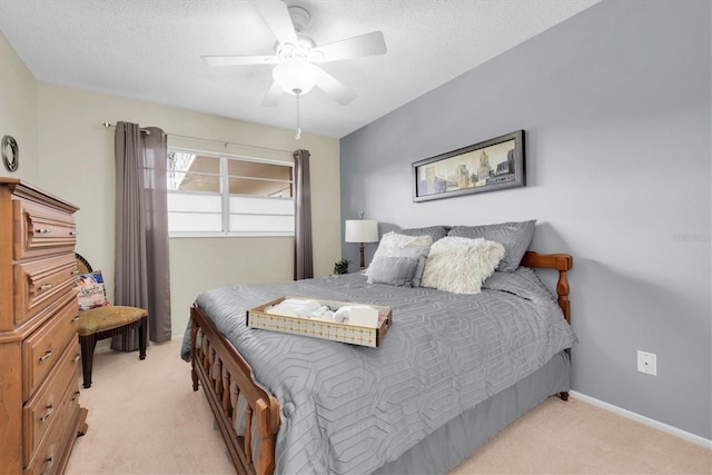 bedroom featuring light carpet, a textured ceiling, and ceiling fan