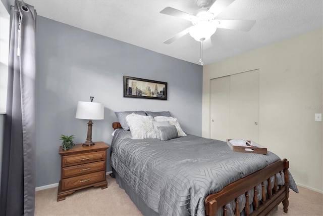 carpeted bedroom featuring ceiling fan, a textured ceiling, and a closet