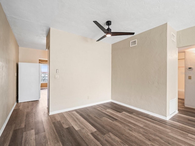 empty room with dark hardwood / wood-style floors, ceiling fan, and a textured ceiling