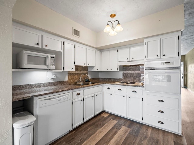 kitchen featuring sink, hanging light fixtures, a textured ceiling, white appliances, and white cabinets