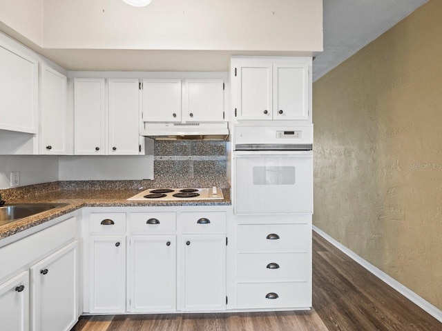 kitchen featuring white cabinets, white appliances, dark hardwood / wood-style floors, and sink