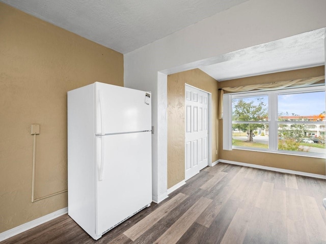 kitchen with hardwood / wood-style floors, white refrigerator, and a textured ceiling