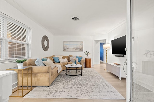 living room featuring light wood-type flooring and ornamental molding