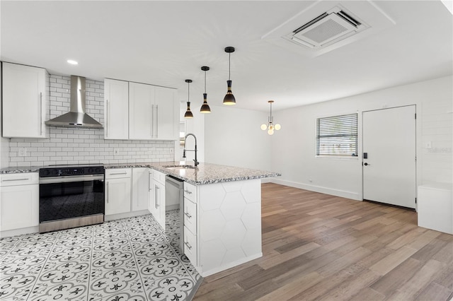 kitchen featuring appliances with stainless steel finishes, white cabinetry, wall chimney exhaust hood, and sink