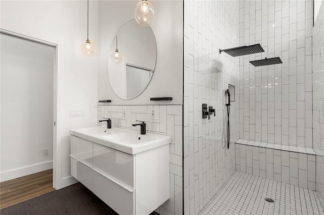 bathroom with vanity, wood-type flooring, and tiled shower