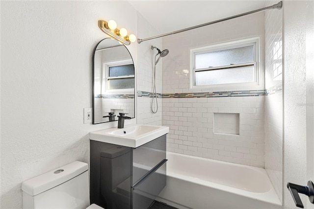 full bathroom featuring plenty of natural light, toilet, vanity, and tiled shower / bath combo