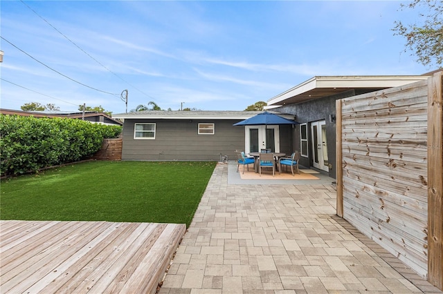 rear view of house with a lawn and a patio