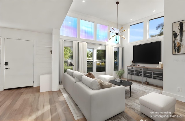 living room with plenty of natural light, a notable chandelier, and light hardwood / wood-style floors