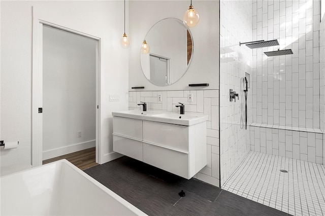 bathroom featuring backsplash, vanity, hardwood / wood-style flooring, and a tile shower