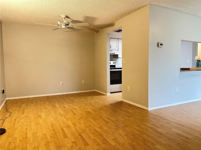 spare room featuring a textured ceiling, ceiling fan, and light wood-type flooring