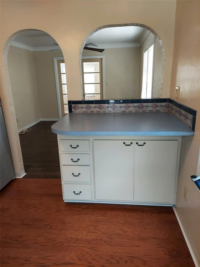 kitchen featuring a wealth of natural light, dark hardwood / wood-style flooring, white cabinets, and ornamental molding