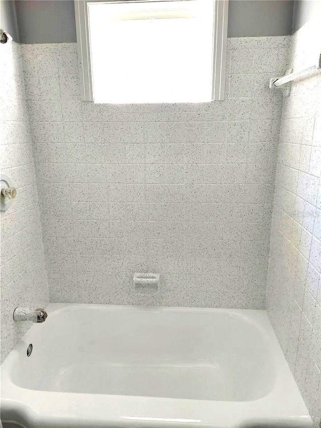 bathroom with a tub and a wealth of natural light