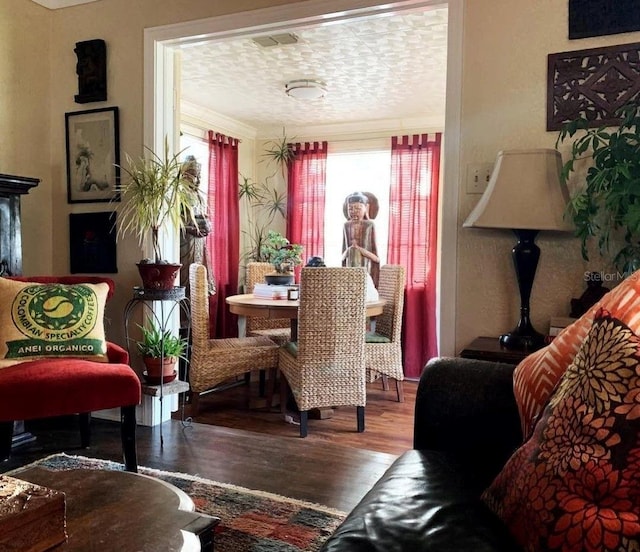 dining room with hardwood / wood-style flooring, a textured ceiling, and crown molding