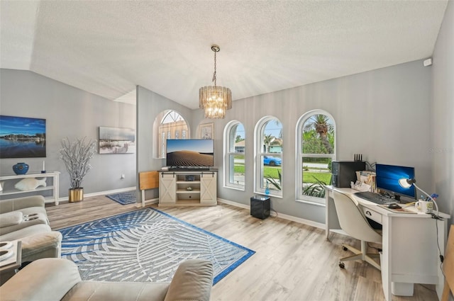 living room featuring lofted ceiling, hardwood / wood-style floors, a textured ceiling, and a notable chandelier