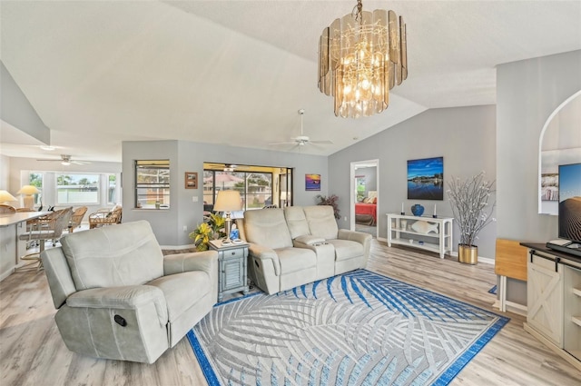 living room featuring ceiling fan with notable chandelier, light hardwood / wood-style floors, and vaulted ceiling