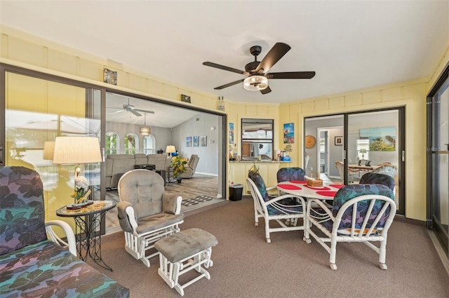 carpeted dining room with ceiling fan