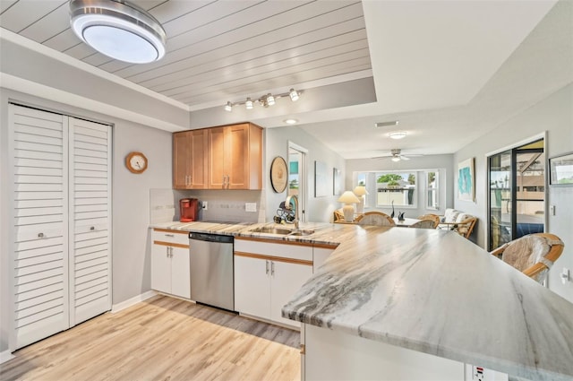 kitchen with tasteful backsplash, dishwasher, sink, kitchen peninsula, and light wood-type flooring