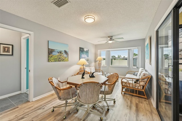 living area featuring a textured ceiling, ceiling fan, and light wood-type flooring