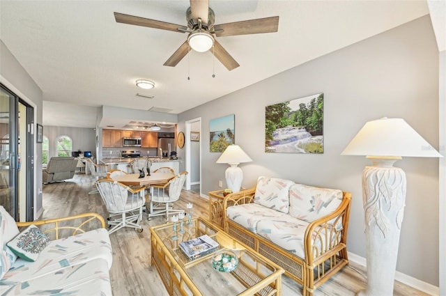 living room with ceiling fan and light hardwood / wood-style floors