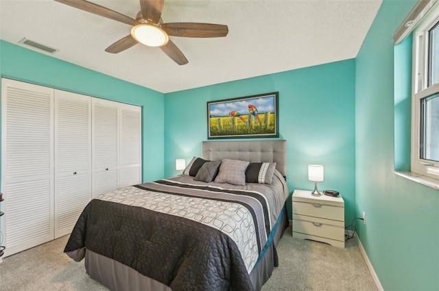 carpeted bedroom featuring a closet and ceiling fan