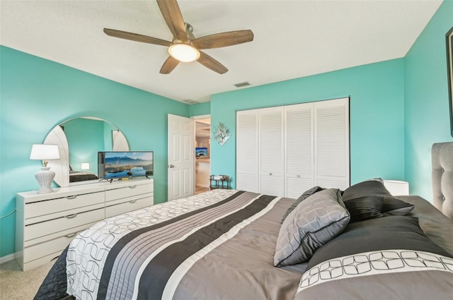 carpeted bedroom with ceiling fan and a closet