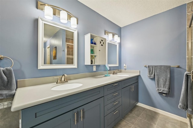 bathroom with tile patterned flooring, vanity, and a textured ceiling