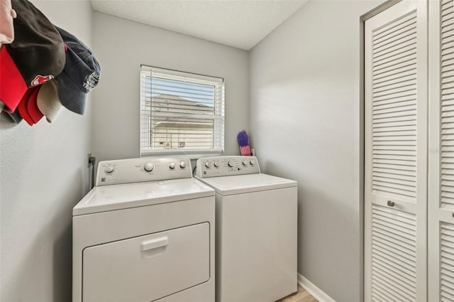 clothes washing area featuring washer and clothes dryer and a textured ceiling