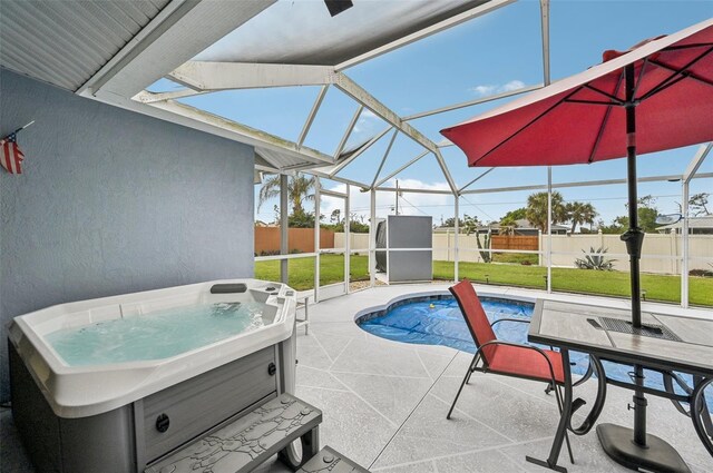 view of swimming pool featuring a hot tub, a lanai, a yard, and a patio area