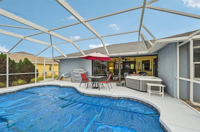 view of pool with ceiling fan, a patio, and glass enclosure