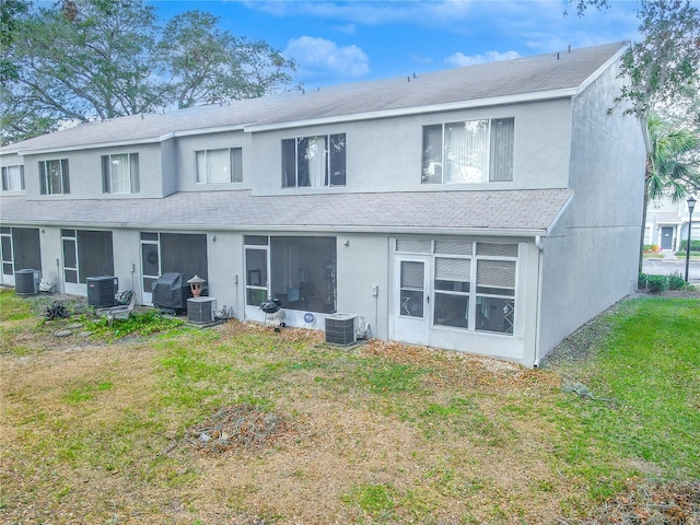 back of house featuring a lawn and central AC