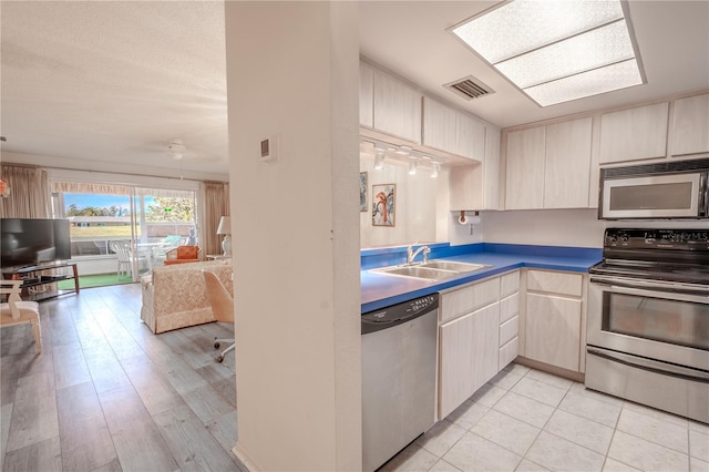 kitchen featuring sink, light brown cabinets, and appliances with stainless steel finishes