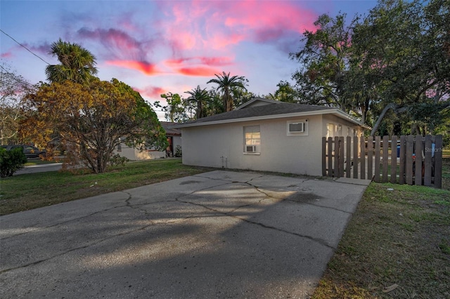 property exterior at dusk featuring a yard