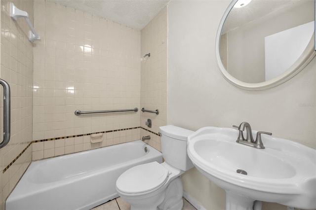 full bathroom featuring sink, tile patterned flooring, tiled shower / bath combo, toilet, and a textured ceiling