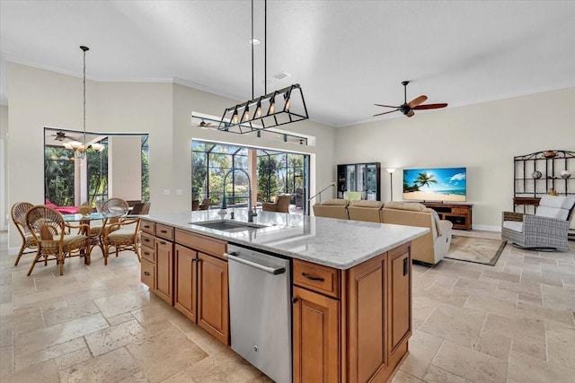 kitchen featuring light stone countertops, stainless steel dishwasher, sink, decorative light fixtures, and a center island with sink