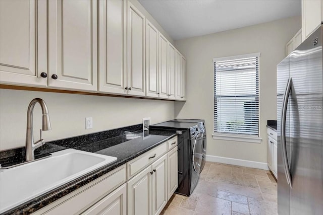 washroom featuring washing machine and clothes dryer, sink, and cabinets