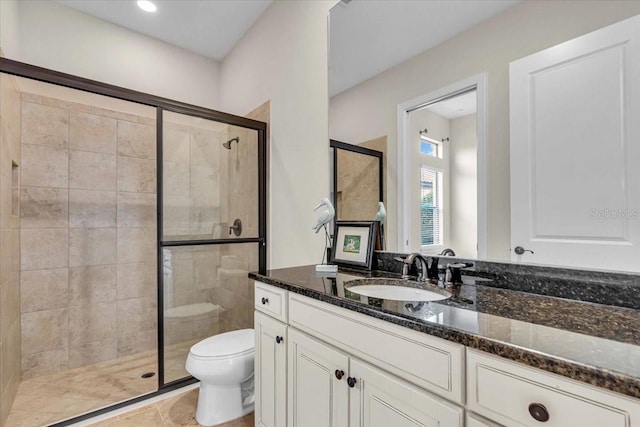 bathroom with tile patterned floors, vanity, toilet, and a shower with shower door