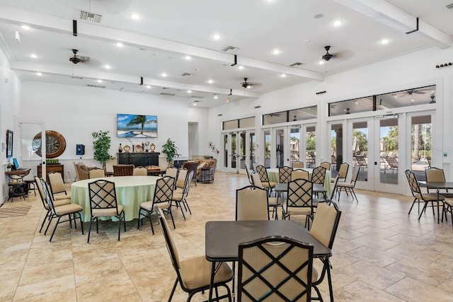 dining space with french doors, ceiling fan, and beam ceiling