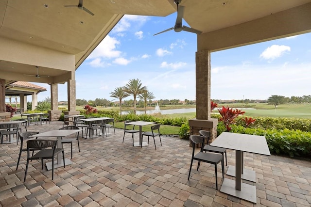 view of patio / terrace with ceiling fan and a water view