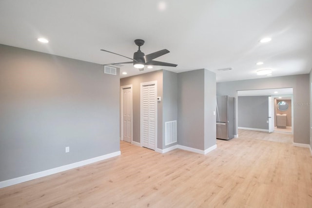 spare room with ceiling fan and light wood-type flooring