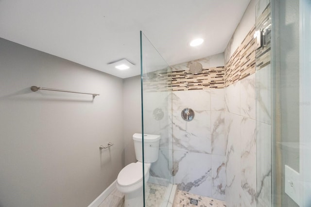 bathroom with tiled shower and toilet